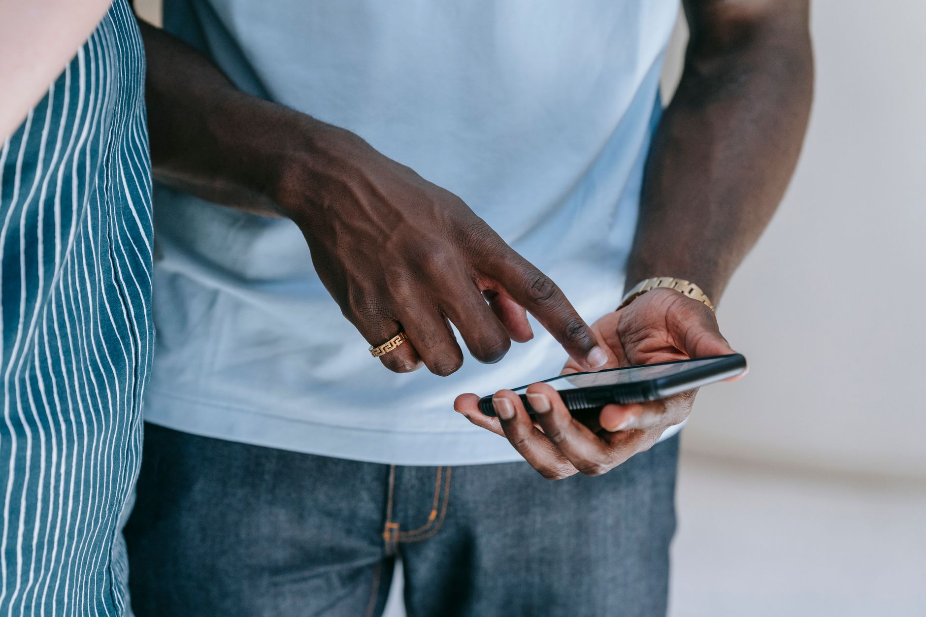 Una mano indica lo schermo di uno smartphone tenuto nell’altra mano